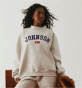 Woman wearing a gray sweatshirt with 'JOHNSON 17' text on a plain background